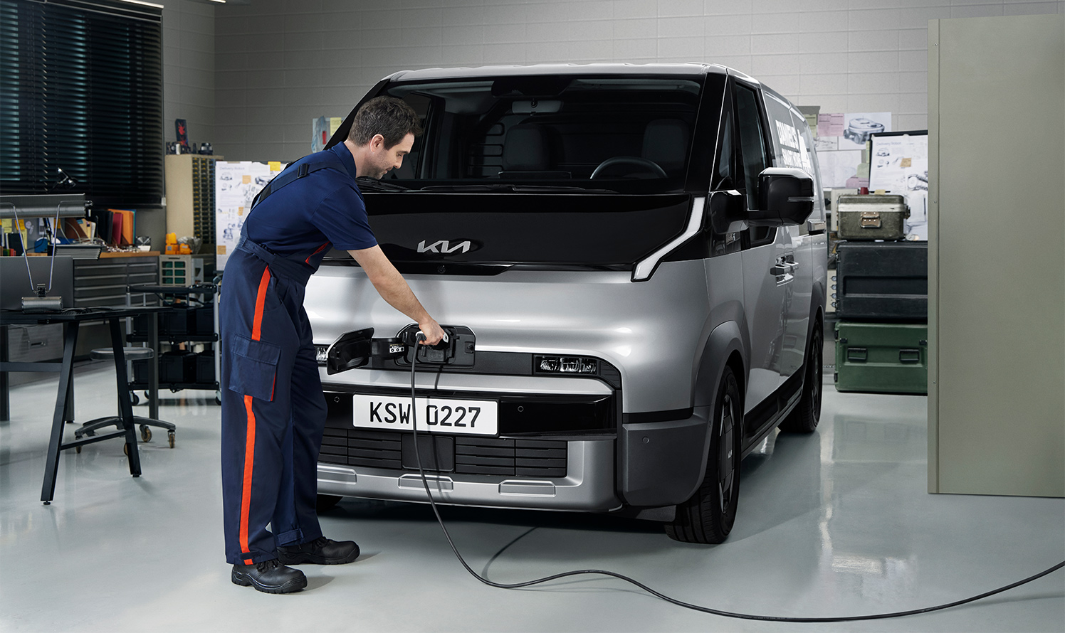 Der Kia PV5 Cargo wird von einem Servicemitarbeiter geladen.